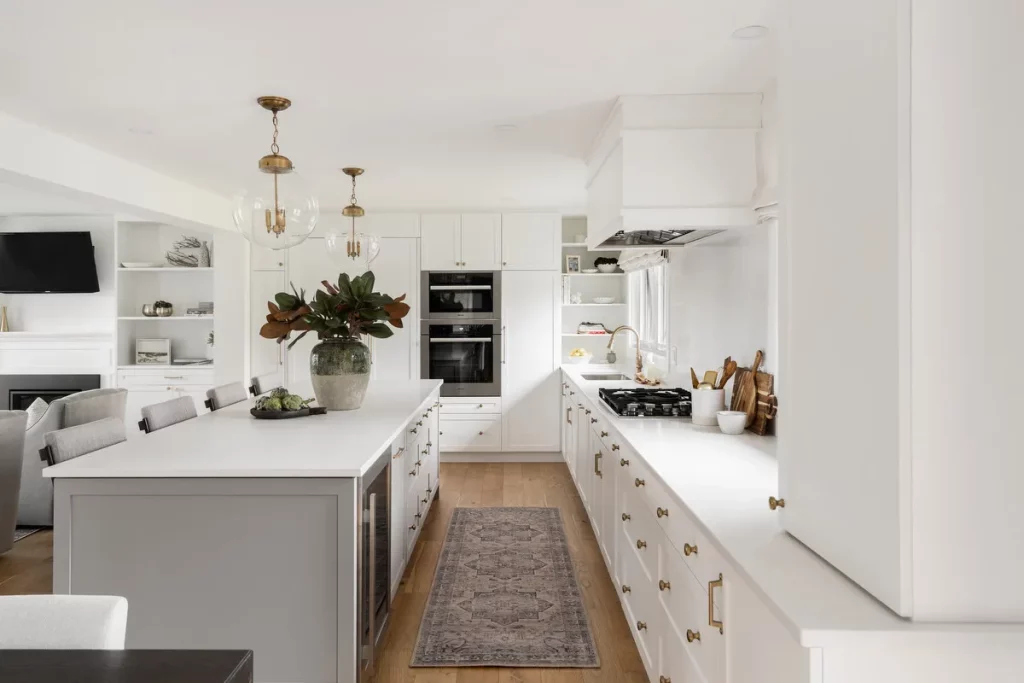 White, open-concept kitchen with brass hardware.