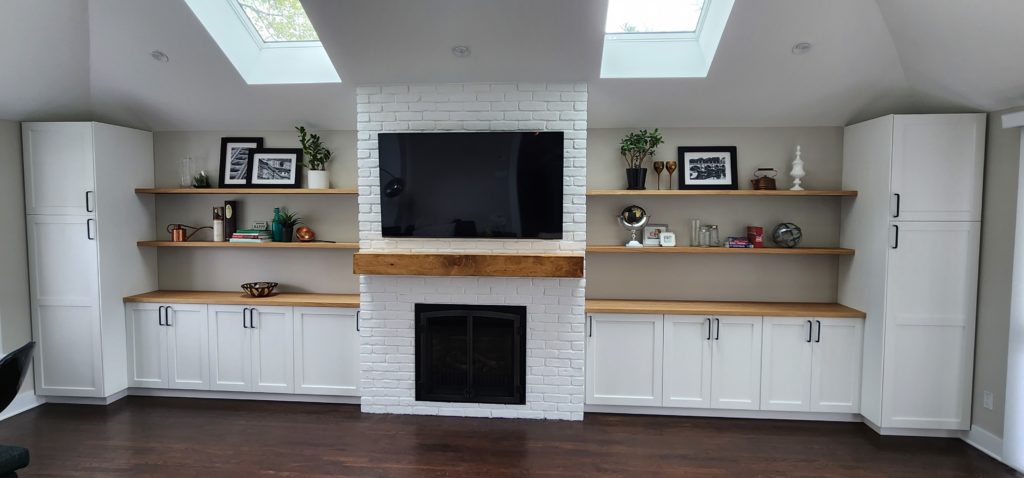 Interior shot showing fireplace, cabinetry and open shelving.