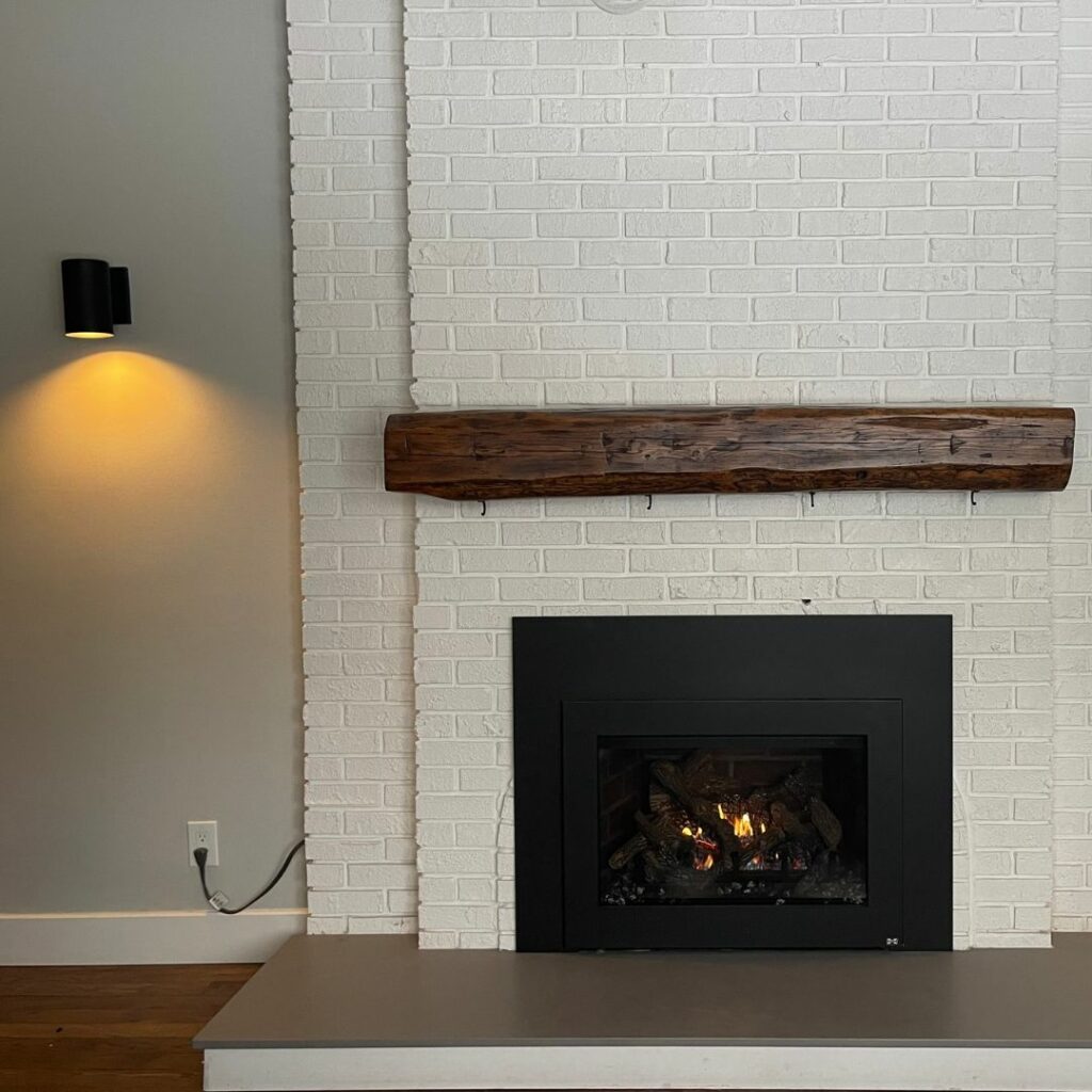 Interior shot of a white brick fireplace with propane insert.